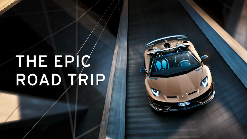 Une Lamborghini Aventador de couleur rouille roule sur une route dans une image promotionnelle avec le texte "The Epic Road Trip" à côté.